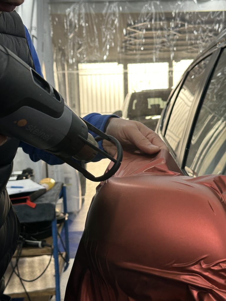 Chauffe d'un film covering au décapeur sur une portière – pourquoi une formation complète réduit les abandons en