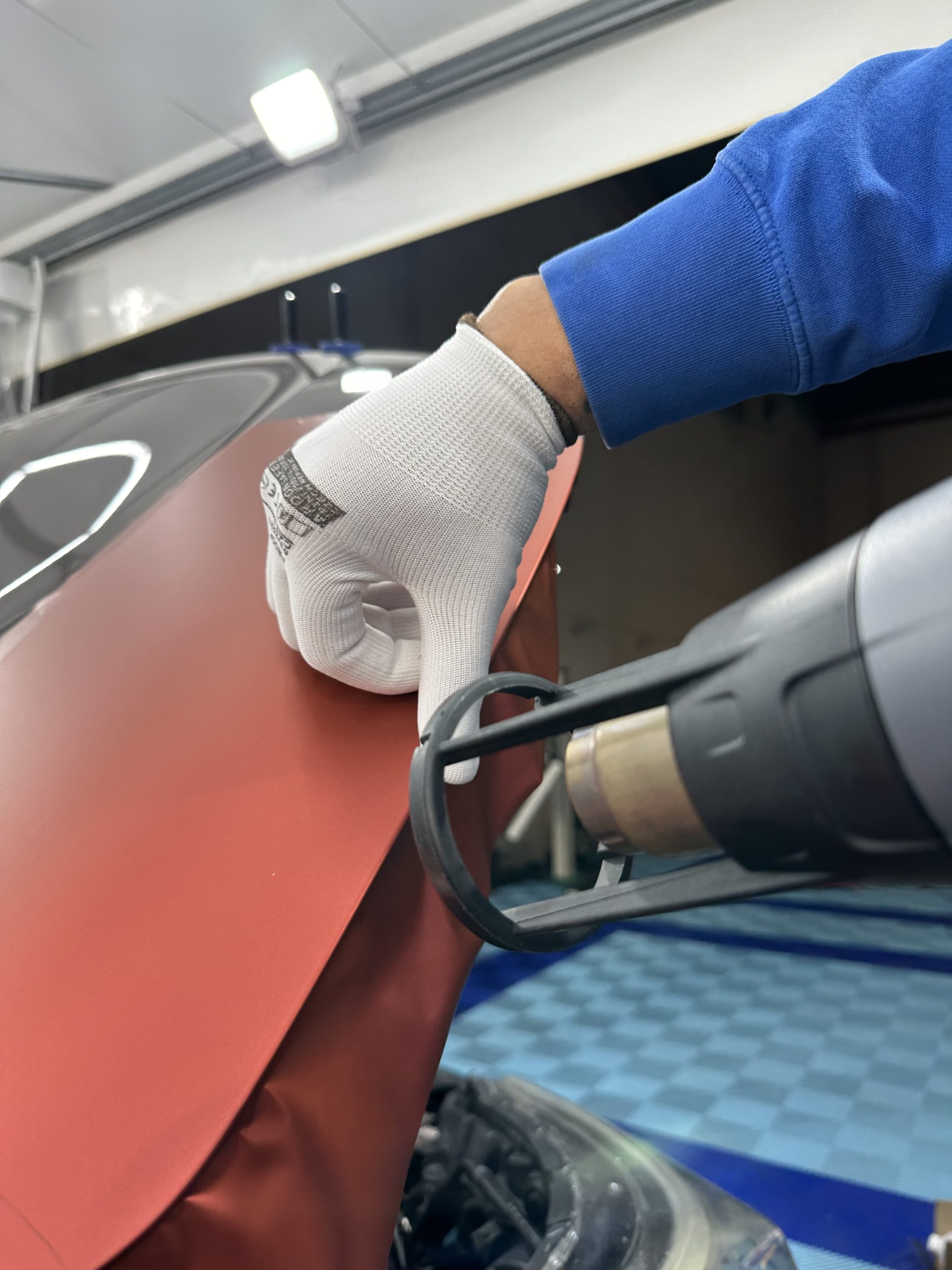 Chauffe d'un film covering rouge au décapeur thermique en atelier – l'Impact et l'Attrait du Covering Mat Foncé