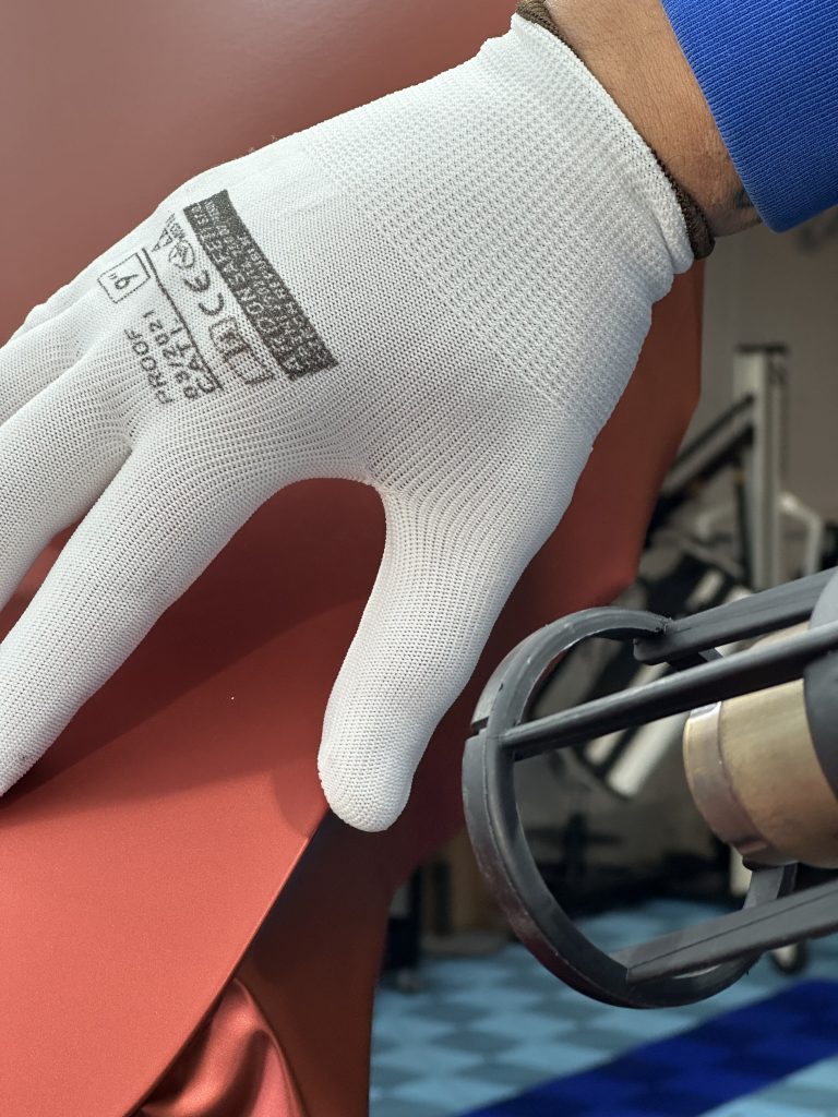 Gants de pose sur un film covering rouge – combiner covering, PPF et films solaires