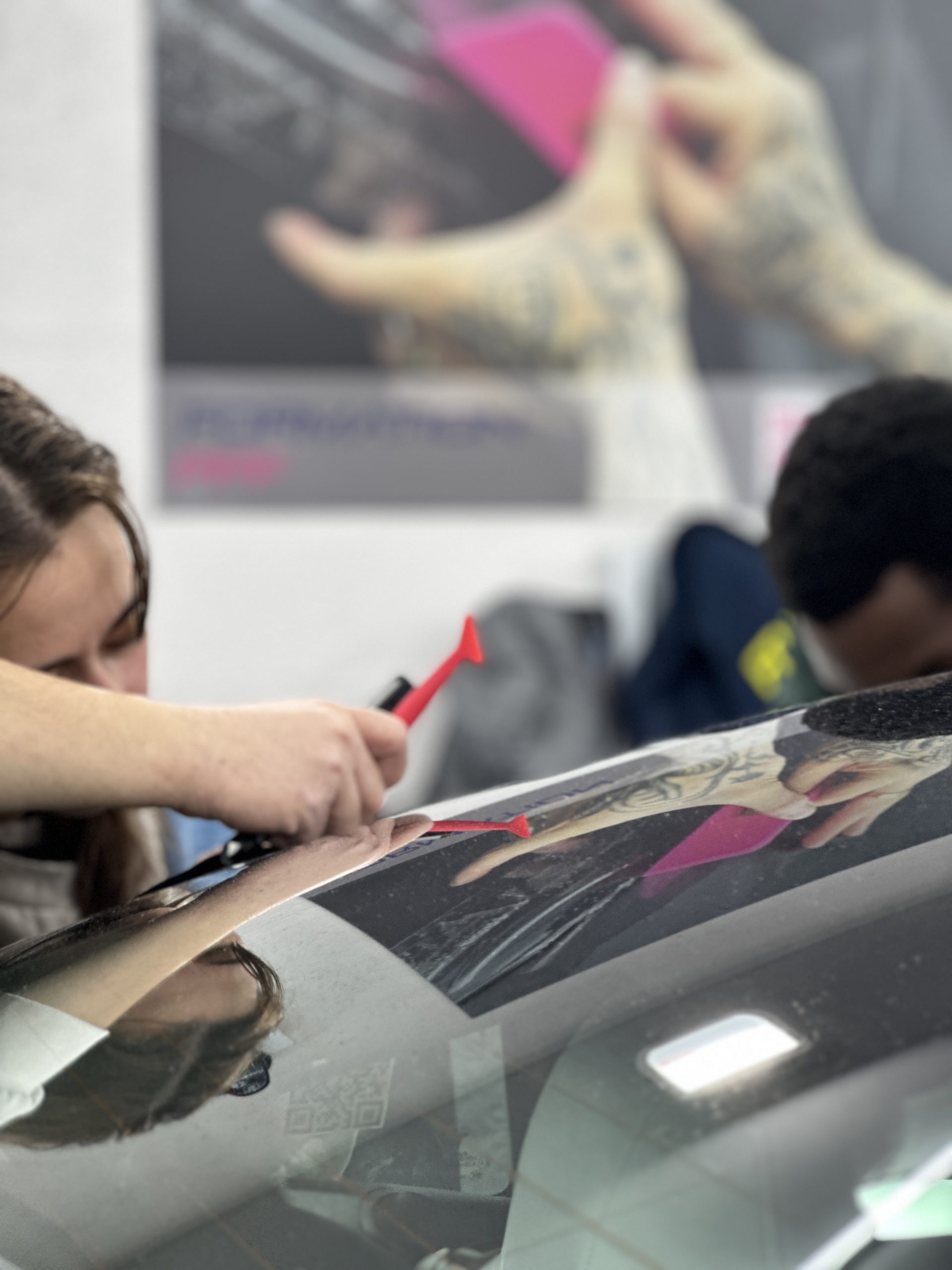 Stagiaires posant un covering sur un pare-brise – comment devenir poseur de covering professionnel