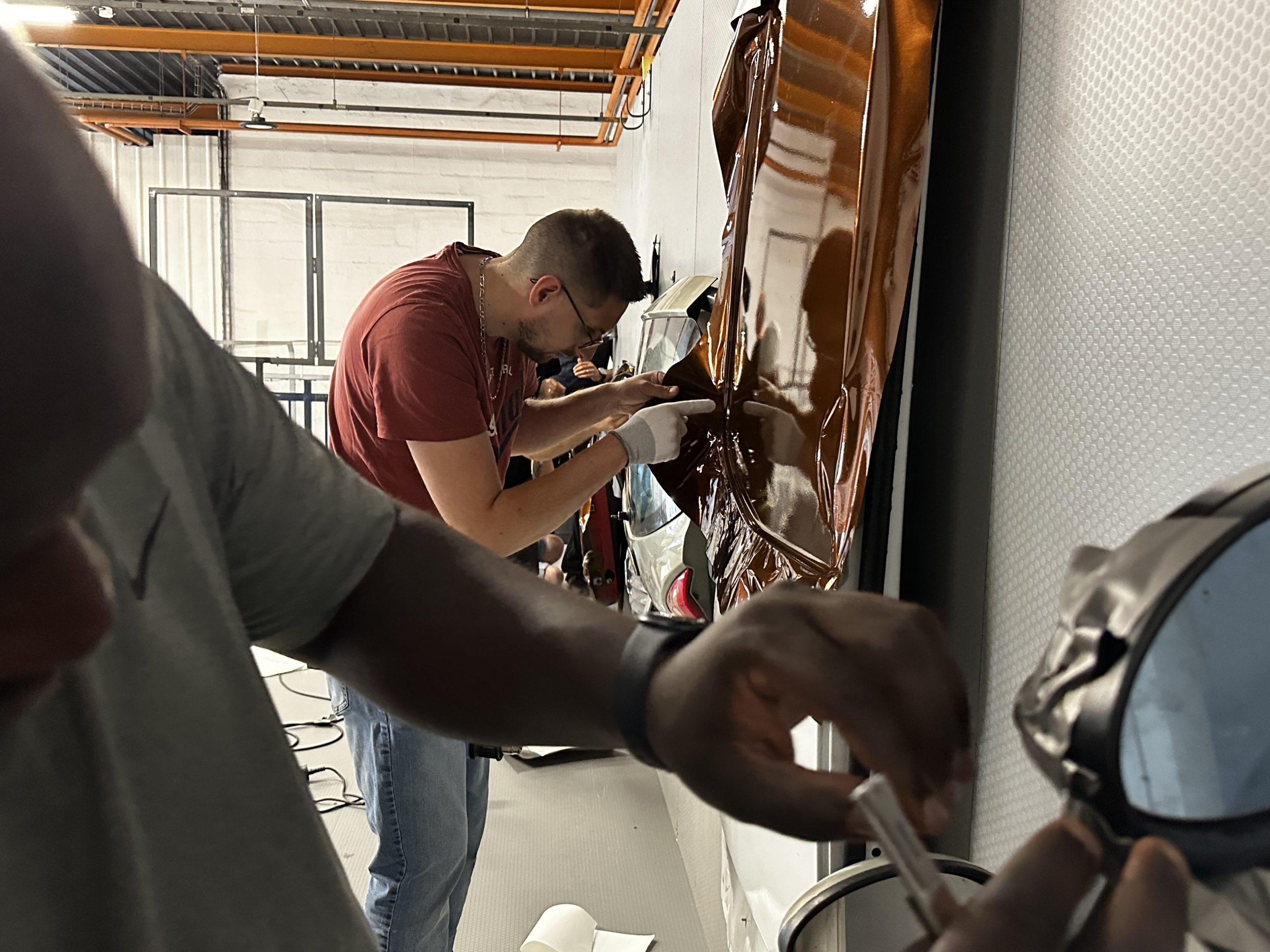Stagiaires posant un film covering imitation bois en atelier – combiner covering, PPF et films solaires