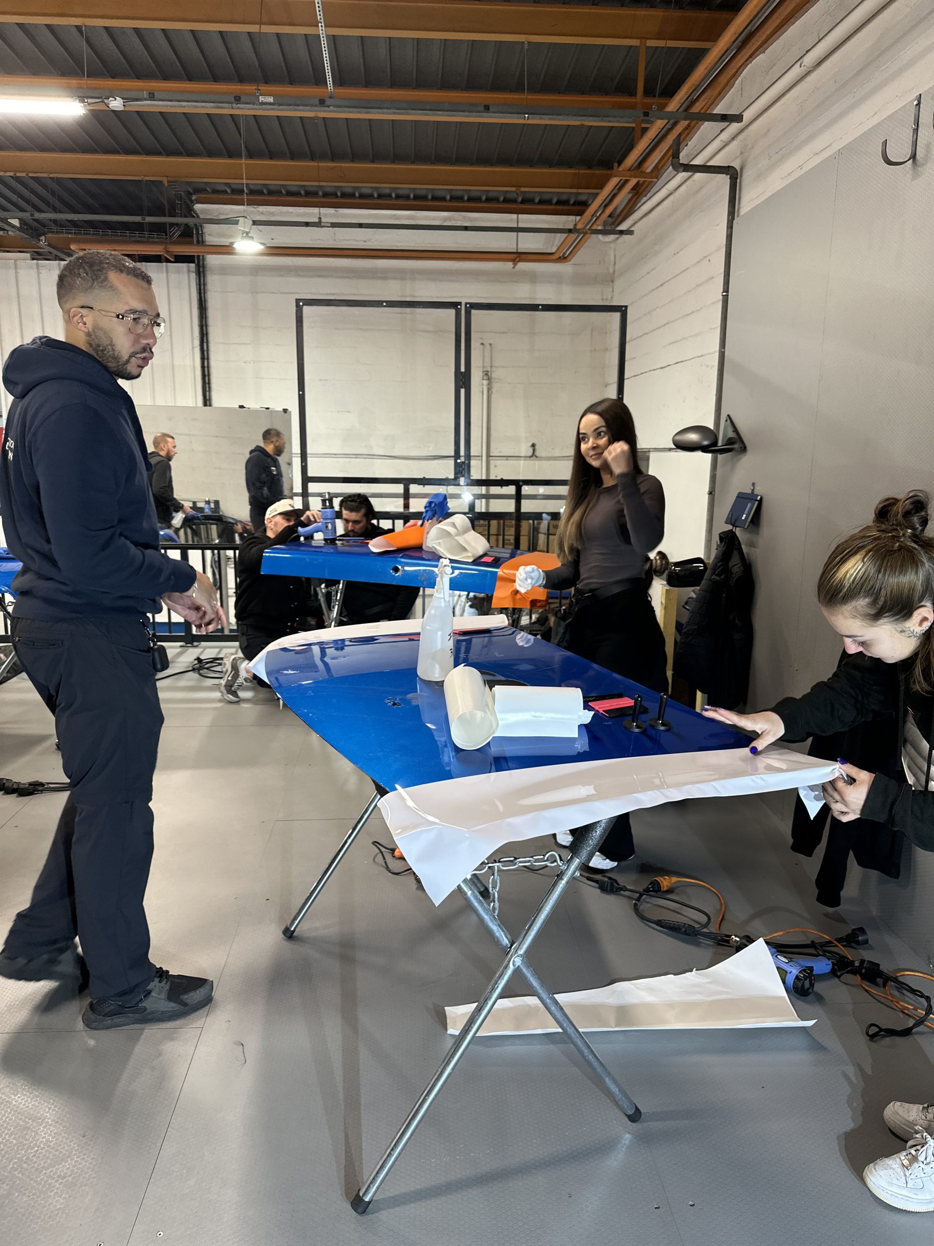 Atelier de formation covering avec stagiaires autour d'une table de travail – formation covering auto 4 jours