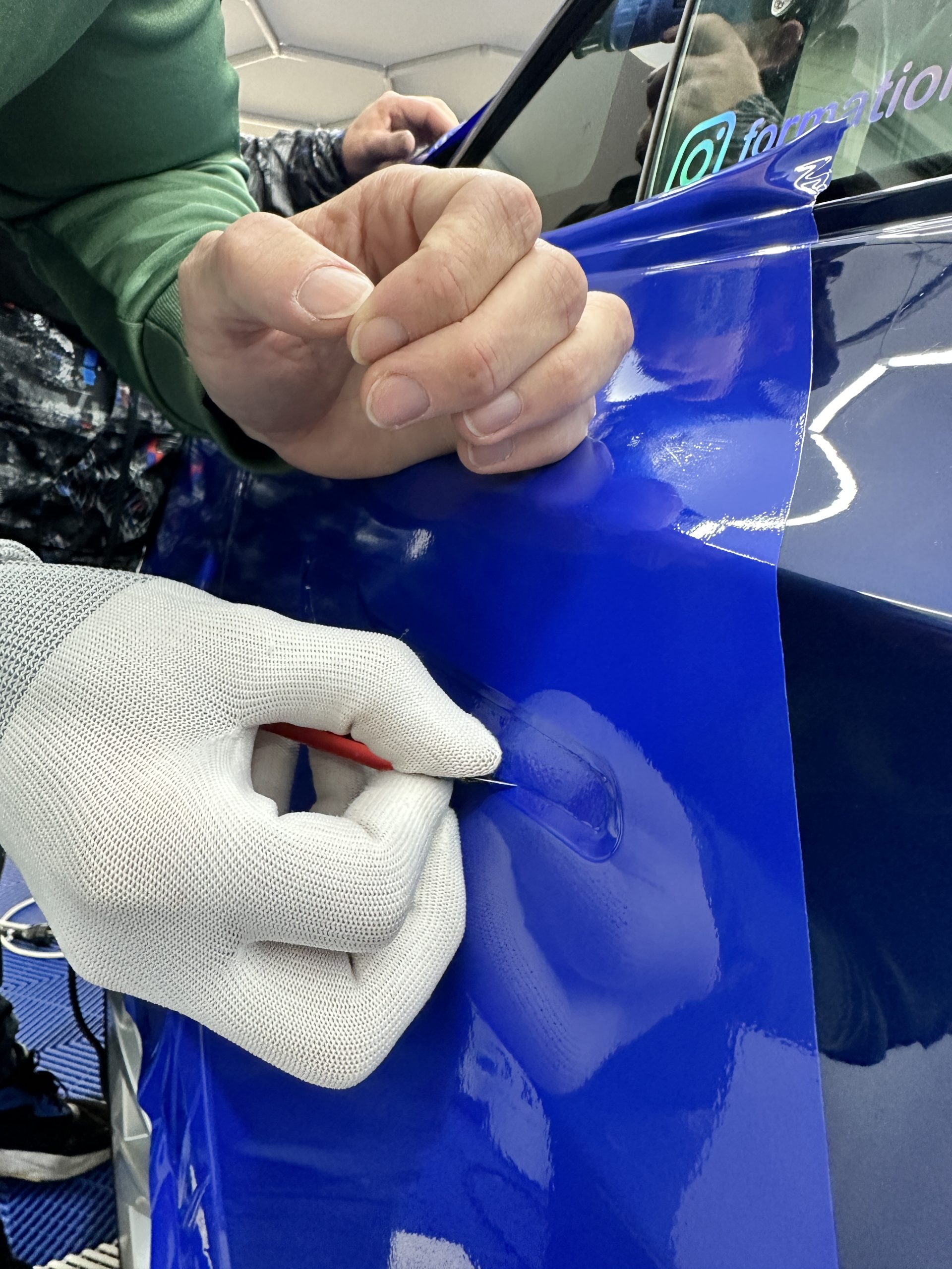 Pose d'un film covering bleu avec gants de pose – comment devenir poseur de covering