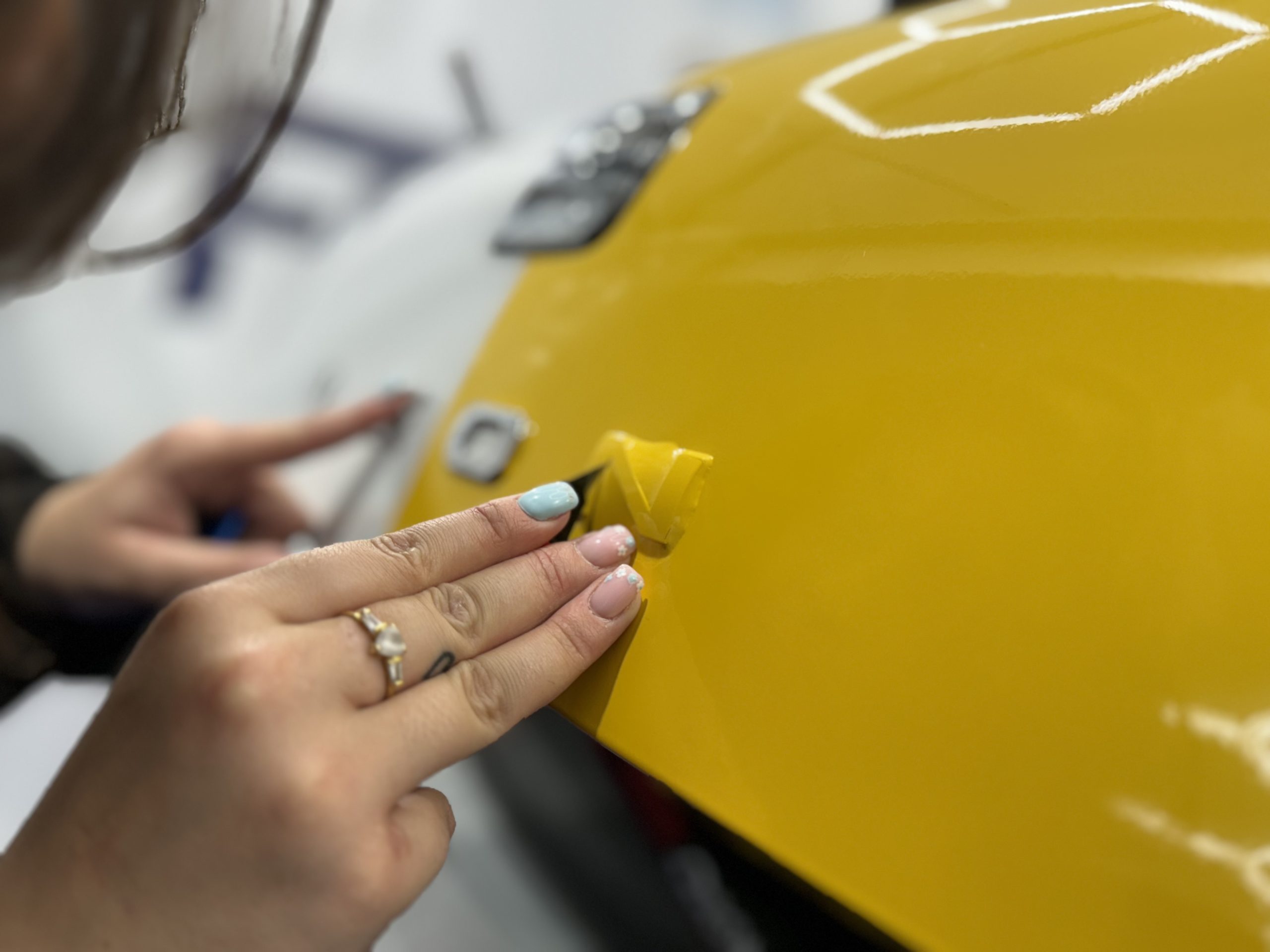 Finition d'un film covering jaune autour d'un emblème – durée de vie d'un covering auto