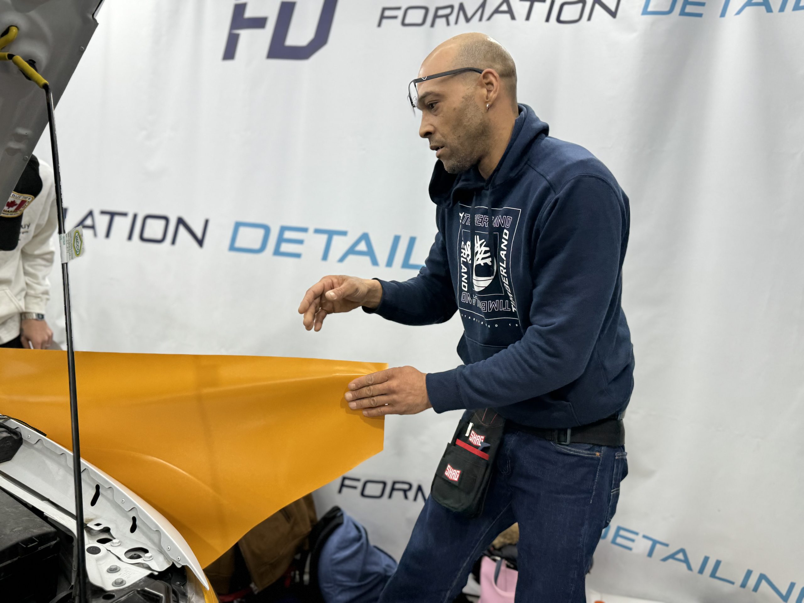 Formateur posant un film covering orange en atelier – retirer un film vinyle sans chaleur