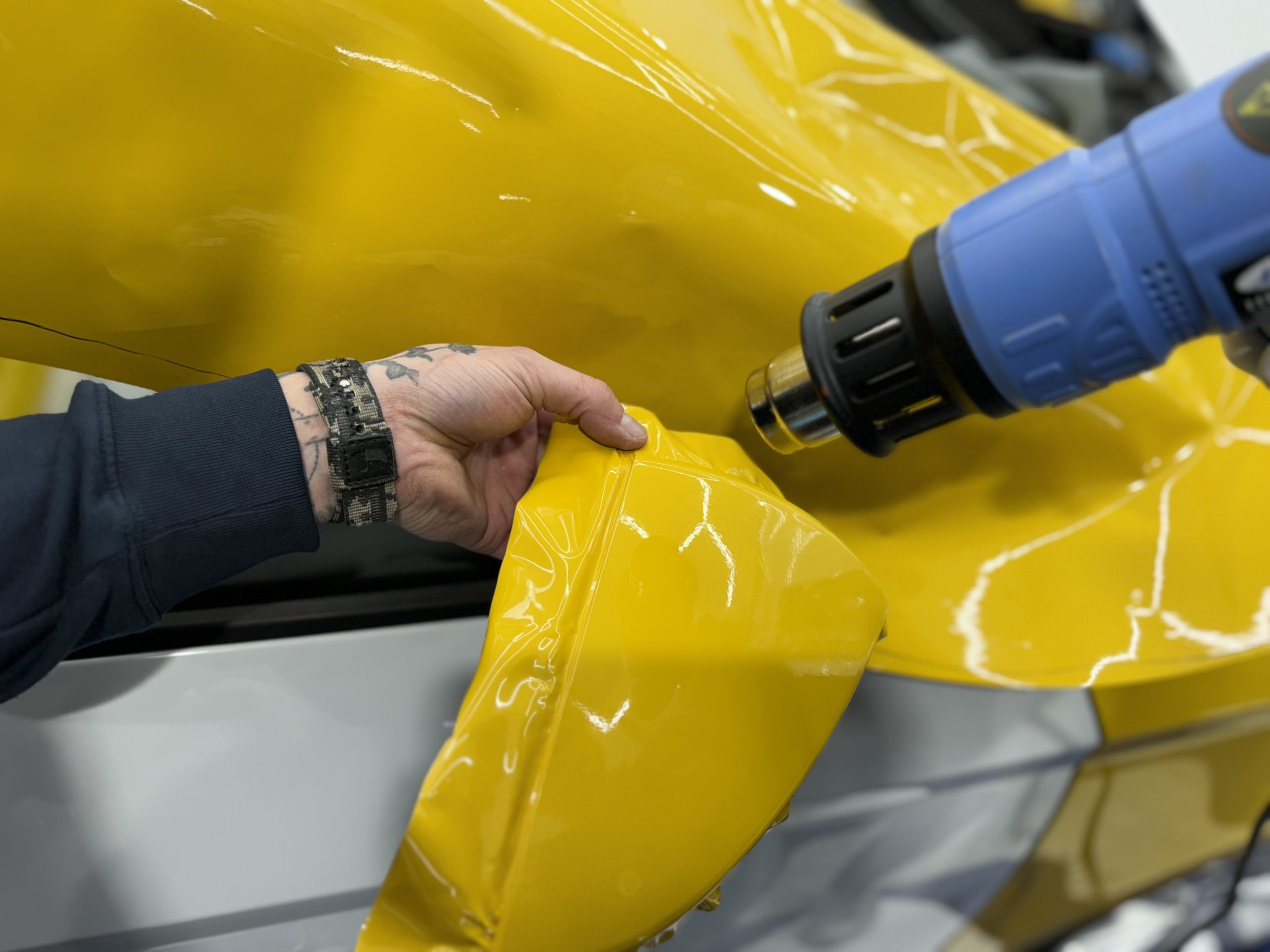 Chauffe d'un film covering jaune au décapeur thermique – comprendre le Coût du Covering Automobile