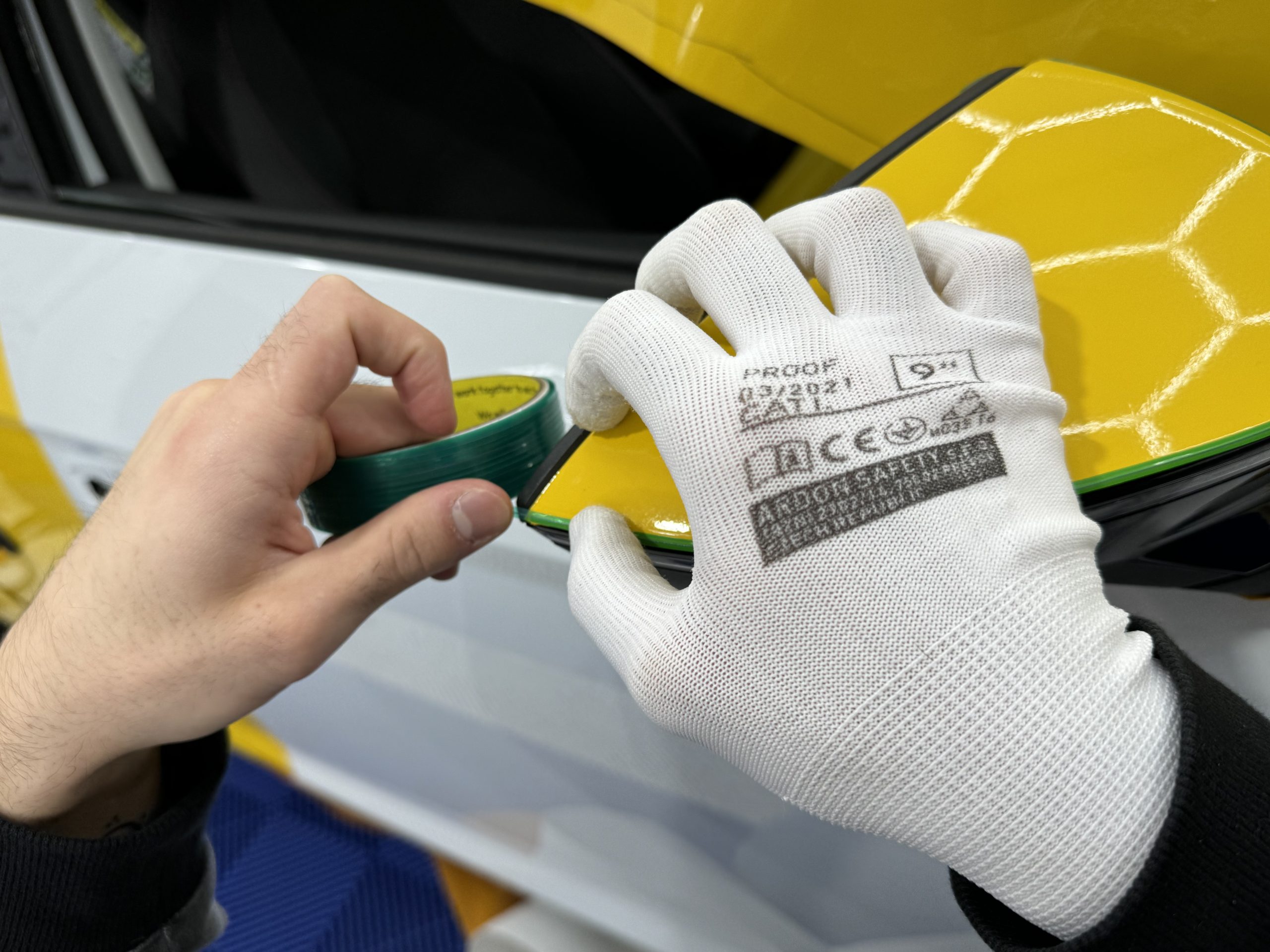 Raclette et gants de pose sur un film covering jaune – salaire poseur de covering