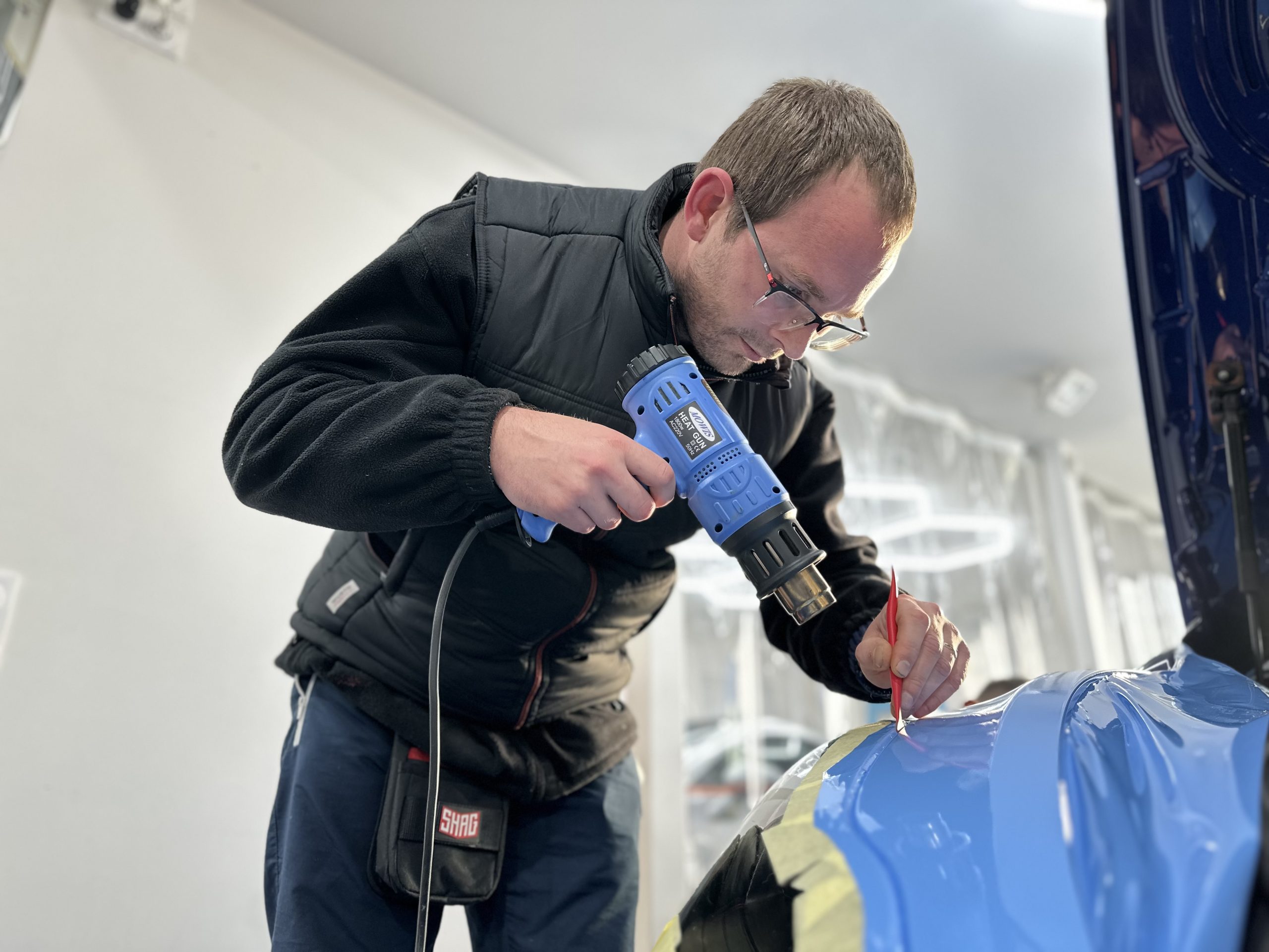 Formateur chauffant un film covering bleu au décapeur – comment devenir poseur de covering